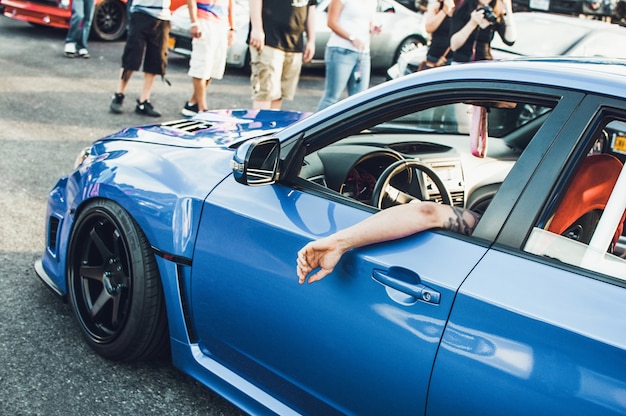 L'homme est assis dans BMW bleu dans la rue